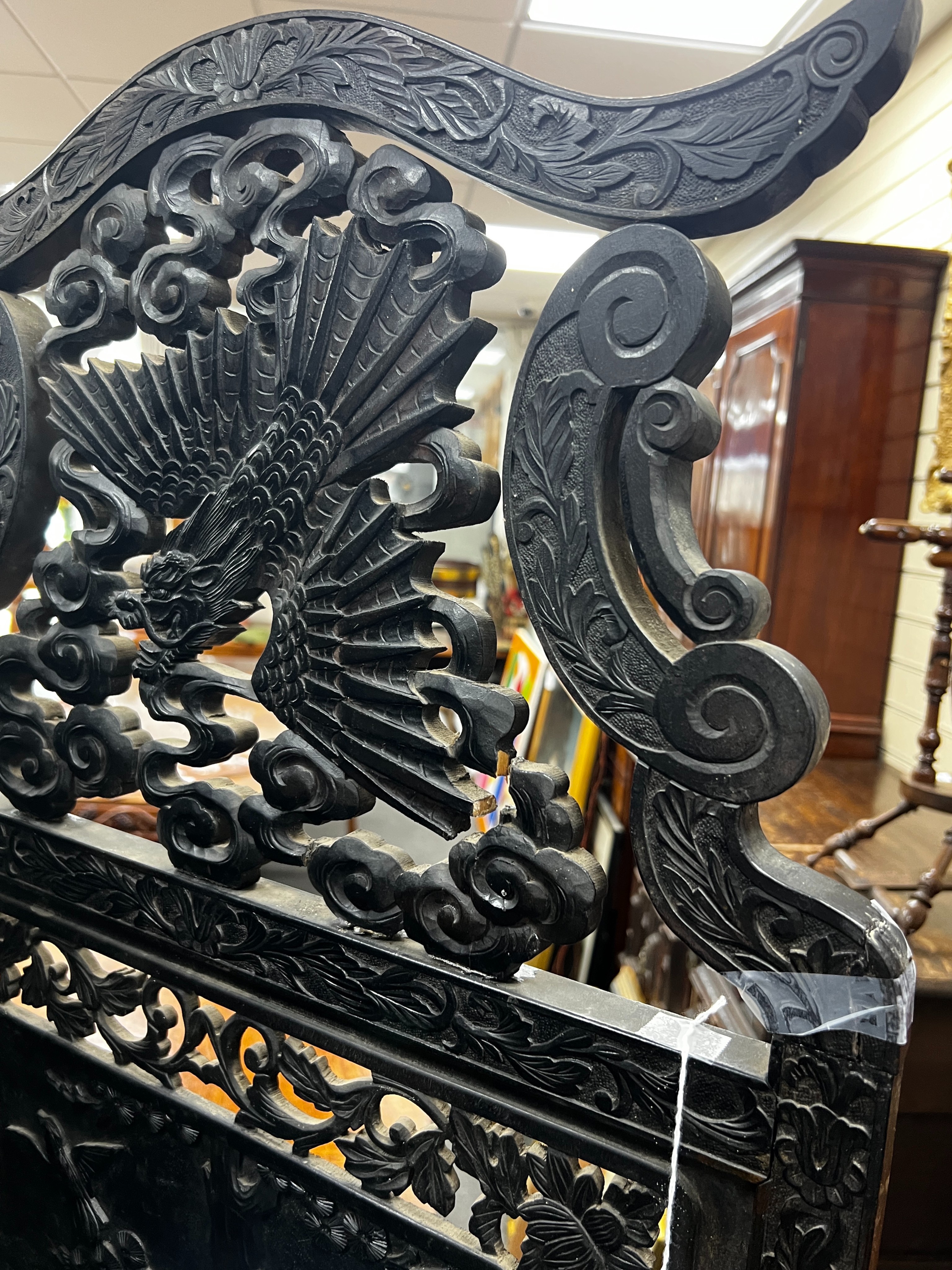 An early 20th century Japanese carved ebonised wood four fold dressing screen, width 56cm, height 173cm